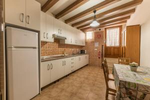 a kitchen with a table and a white refrigerator at Rapia. Casa Beig 4 