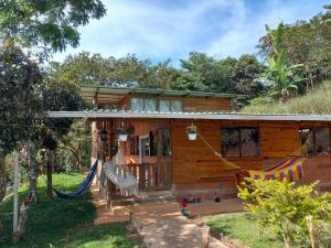 a house with a hammock in front of it at LA CASA DEL BOSQUE Via SALADITO in La Elvira +64 photos