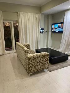 uma sala de estar com um sofá e uma televisão de ecrã plano em 6th on Brooke av em Joanesburgo