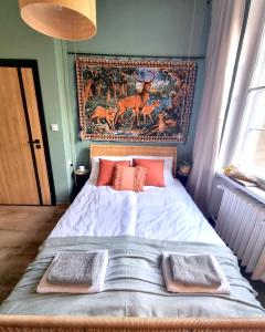 uma cama num quarto com uma tapeçaria na parede em Cozy&Retro - Old Town Apartament em Gdansk