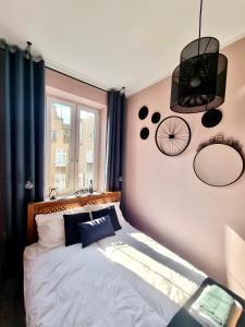 um quarto com uma cama com almofadas azuis e uma janela em Cozy&Retro - Old Town Apartament em Gdansk