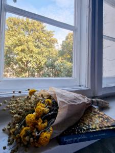 um ramo de flores sentado no parapeito da janela em Cozy&Retro - Old Town Apartament em Gdansk