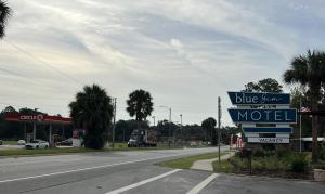 um sinal para um motel na beira de uma estrada em BlueGem Motel em High Springs