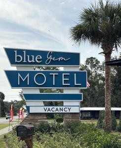 a sign for a blue gem motel with a palm tree at BlueGem Motel in High Springs