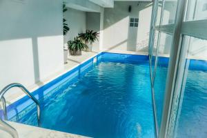 a swimming pool in a building with blue water at Konke Buenos Aires Hotel in Buenos Aires