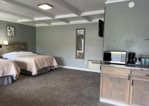 a hotel room with two beds and a television at BlueGem Motel in High Springs