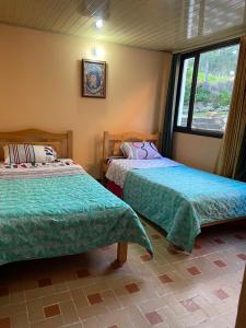 een slaapkamer met 2 bedden en een raam bij Apartamento En Pueblito Boyacense in Duitama