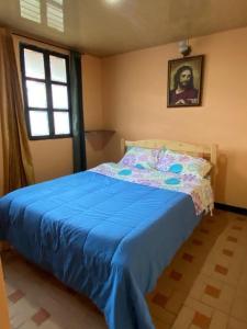 a bedroom with a bed with a blue blanket at Apartamento En Pueblito Boyacense in Duitama