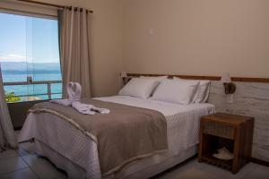 a bedroom with a bed with an elephant toy on it at La Coquille in Praia de Araçatiba