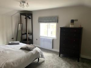 a bedroom with a bed and a dresser and a window at RECENTLY RENOVATED property in the heart of Southwell in Southwell