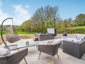 a patio with a table and chairs and a grill at Cefn Gelli in Clynderwen