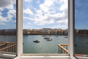 una finestra con vista su un porto con barche in acqua di El Doris Boutique Living a Marsaskala