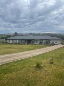 a house with a car parked on a road at Gibbagunyah Manor Workers Accommodation Only in Muswellbrook