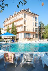 a swimming pool with chairs and a building at Tvorcheskaya Volna Resort in Koktebel