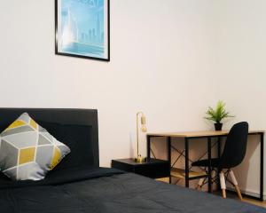 ein Schlafzimmer mit einem Bett, einem Schreibtisch und einem Tisch in der Unterkunft Bella Luna II - Elégant appartement centre ville - Parking gratuit - Wifi ultra rapide-Appareil Massage-Netflix-Jeu société in Troyes