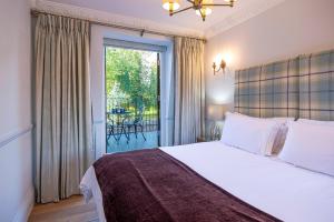 1 dormitorio con 1 cama y balcón con mesa en Eagles Nest at Greyfriars, en Winchelsea