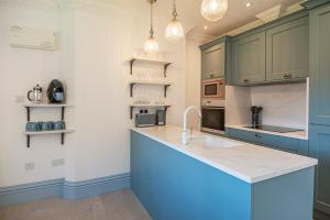 una cucina con armadi blu e piano di lavoro di Eagles Nest at Greyfriars a Winchelsea