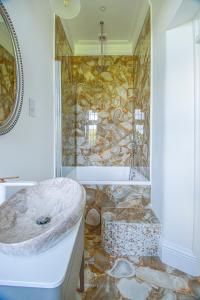baño con bañera y pared de piedra en Eagles Nest at Greyfriars, en Winchelsea