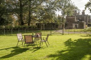 einen Tisch und Stühle im Gras im Hof in der Unterkunft Eagles Nest at Greyfriars in Winchelsea