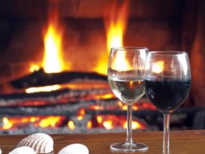 two glasses of wine in front of a fireplace at Lar Atlantis in Basoñas