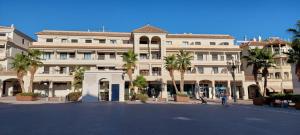 a large building with palm trees in front of it at Maravilloso apartamento in Nerja