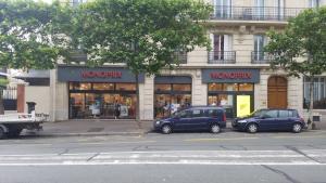 Dos coches aparcados delante de una tienda en Appartement 2 PCS au metro BERAULT, en Vincennes