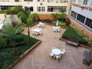 a courtyard with tables and chairs in a building at BestHostRio - Amplo Imóvel Copa Posto 6 com Piscina e Garagem in Rio de Janeiro