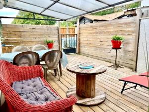 patio ze stołem i krzesłami na drewnianym tarasie w obiekcie Maisonnette Bassin d'Arcachon w mieście La Teste-de-Buch