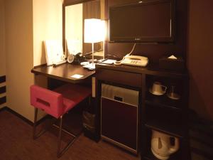a hotel room with a desk with a television and a red chair at Vessel Inn Hakata Nakasu in Fukuoka
