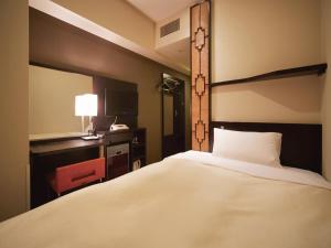 a hotel room with a bed and a desk and a television at Vessel Inn Hakata Nakasu in Fukuoka