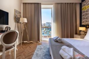 a hotel room with a bed and a large window at El Doris Boutique Living in Marsaskala