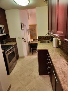 a kitchen with a sink and a stove top oven at Mantell Plaza Apartments in Miami Beach