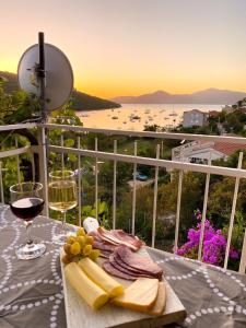 a table with a plate of food and glasses of wine at Apartments Rade Bigovo in Tivat