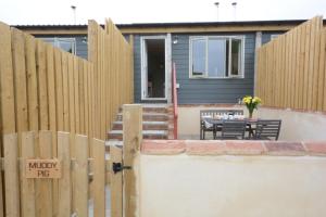 a fence in front of a house with a table at Muddy Pig, Ubbeston in Laxfield