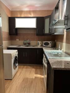 a kitchen with a washing machine and a washer at Ronza Elegant Apartment in Amman