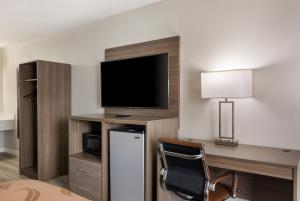 a hotel room with a television and a desk with a chair at Quality Inn in Emporia