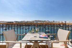 a table with two chairs and a view of the water at Eldoris Boutique Living in Marsaskala
