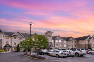 un edificio con coches estacionados en un estacionamiento en Stay-Over Suites - Fort Gregg-Adams Area en Hopewell