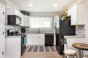 a kitchen with white cabinets and a black refrigerator at Cute Apt near Atlanta Airport-3A in Atlanta