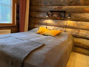 a bedroom with a bed with a wooden wall at Kelomaja Ylläs in Äkäslompolo