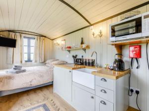 eine Küche mit einem Waschbecken und ein Bett in einem Zimmer in der Unterkunft Daisys Rest in Shipton under Wychwood