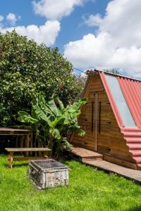 um pequeno chalé de madeira com um telhado vermelho em Casa Cabanas Ponta Delgada em São Roque
