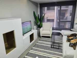 a living room with a couch and a television at Loft silgar in Sanxenxo