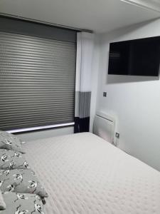 a bedroom with a bed and a flat screen tv at Loft silgar in Sanxenxo