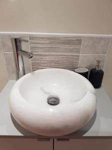 een witte wastafel op een aanrecht in een badkamer bij Bwthyn Mair in Llangefni