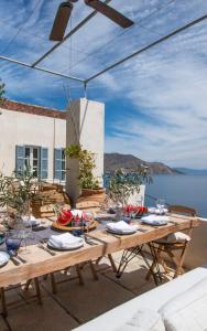 a wooden table on a patio with a view of the ocean at The Anchor House in Symi