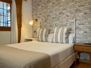 a bedroom with a bed with a brick wall at At Home in Malaga Stay & Solo Travellers in Rincón de la Victoria