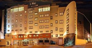 un grande edificio con molte finestre di notte di Hotel Les Ambassadeurs a Orano