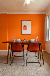 Fast Wifi Luxury 1br Prime Location Huge Bed في لوس أنجلوس: طاولة طعام مع كرسيين وجدار برتقالي