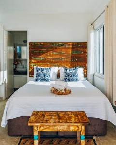 1 dormitorio con 1 cama grande y cabecero de madera en Casa Grega, en Arraial do Cabo
